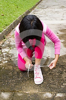 Asian girl tying shoelace