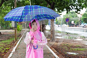 Asian girl with umbrella and raincoat.