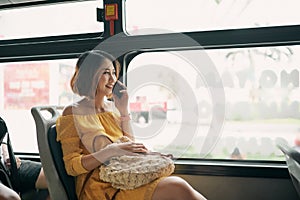 Asian girl using phone on public bus