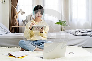 Asian girl using tablet computer in bed