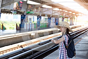 Asian girl waiting train at skytrain station for travel in the b