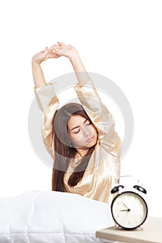 Asian girl wake up and stretching with alarm clock
