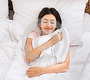 Asian Girl Waking Up In Bed Hugging Blanket, Above View