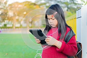 Asian girl watching a table on the school lawn