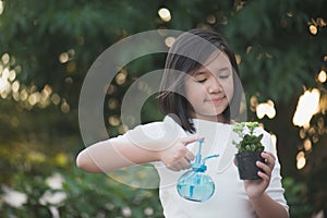 Asian girl watering a red flower in the garden