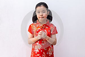 Asian girl wear cheongsam with gesture of congratulation, bring the hands together in greeting. in chinese new year