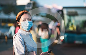 Asian girl wearing face mask at the bus station