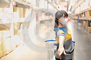 The asian girl wearing surgical mask with the backpack for  shopping the decorate funiture for interior inside the house in the