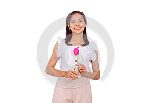 An Asian girl in white tank top and baige trunk holds pink plastic flower in her hands