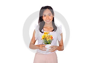 An Asian girl in white tank top and baige trunk holds yellow plastic flower in her hands