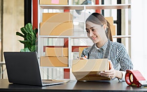 Asian girl working with boxes at home office small business owner start up Entrepreneur, small business, SME or self