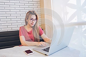 Asian girl working at a coffee shop with a laptop.female freelancer connecting to internet