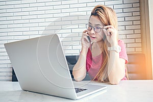 Asian girl working at coffee shop sitting with mobile phone an