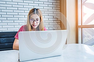 Asian girl working at a coffee shop sitting with mobile phone an