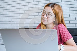 Asian girl working at a coffee shop sitting with mobile phone an