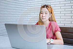 Asian girl working at a coffee shop sitting with mobile phone an