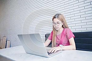 Asian girl working at a coffee shop sitting with mobile phone an