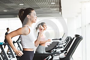 Asian girl working out on treadmill at the gym