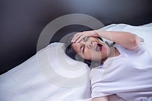 Asian girl yawning on her bed and tired sleepy,symptoms and sleepiness photo