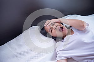 Asian girl yawning on her bed and tired sleepy,symptoms and sleepiness