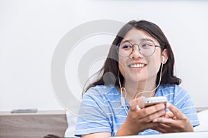 Asian girl young teen student using smartphone listening musi