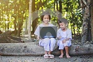 Asian girls and boy using notebook of searching some information