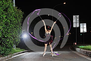 Asian girls dancing ballet on the road at night