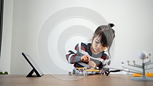 Asian girls enjoy making and fixing electrical robot car and learning online tutor training course