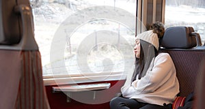 Asian girls are sleeping happily on the train and traveling on a vacation in Switzerland and planning travel by train