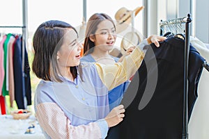 Asian girls teen enjoy shopping to select new cloth with friend in fashion shop like black color cloth