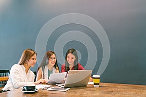 Asian girls using laptop in team business meeting, coworkers or college student, startup project discussion or teamwork brainstorm photo