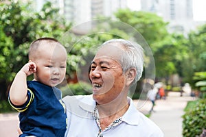 Asian grandfather holding grandson