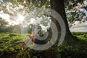 Asian grandmother fisherman with the net bamboo under the big tree