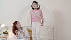 Asian grandmother granddaughter relax at home. Senior Chinese, grandma happy relax with young girl jump enjoy playing together