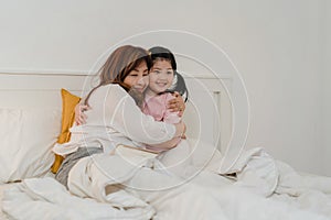 Asian grandmother read fairy tales to granddaughter at home. Senior Chinese, grandma happy relax with young girl enjoy good