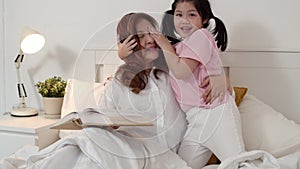Asian grandmother relax at home. Senior Chinese, grandma happy relax with young granddaughter girl enjoy close her eyes surprise