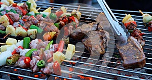 Asian group of friends having outdoor garden barbecue laughing with alcoholic beer drinks on night