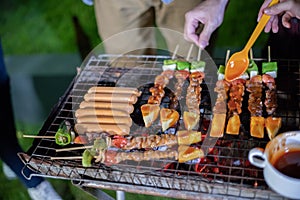 Asian group of friends having outdoor garden barbecue laughing w