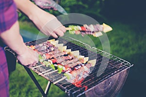 Asian group of friends having outdoor garden barbecue laughing w