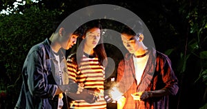 Asian group of friends having outdoor garden barbecue laughing w