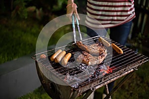 Asian group of friends having outdoor garden barbecue laughing w