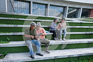 Asian group of students old people and children sitting on the stairs