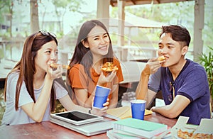 Asian group together eating pizza in breaking time