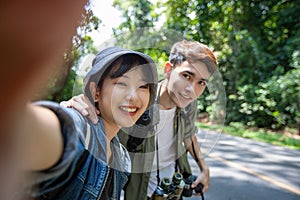 Asian Group of young people with friends and backpacks walking together and happy friends are taking photo and selfie ,Relax time