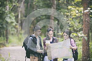 Asian Group of young people Hiking with friends backpacks walking together and looking map and taking photo camera by the road