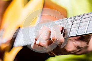 Asian guitarist playing music in recording studio