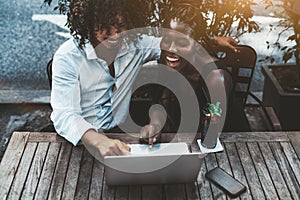 Asian guy and black girl in cafe with laptop