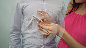 Asian guy presents Valentine card with a wedding ring to young girl on a white background