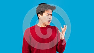 Asian guy showing wrong sneezing and coughing