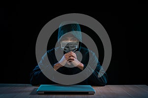 Asian hacker hacking computer network with laptop in dark. Cyber security concept